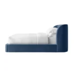 Minimal blue velvet bed frame with fully upholstered structure and rounded edges