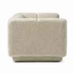Side view of The Plinth Premium Sofa in cream boucle fabric with rounded arms, channel backrest, and low upholstered base.